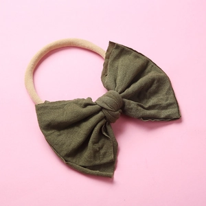 Vue détaillée du nœud en tricot vert olive avec un bandeau bébé en nylon doux
