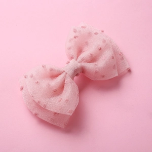 Vue détaillée d'une barrette à cheveux rose en tulle double couche à pois