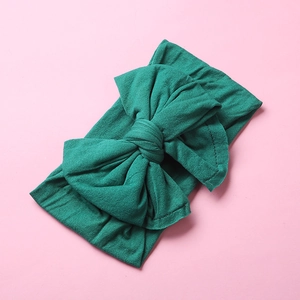 Detailed texture of forest green nylon baby headband with a large double-layered bow