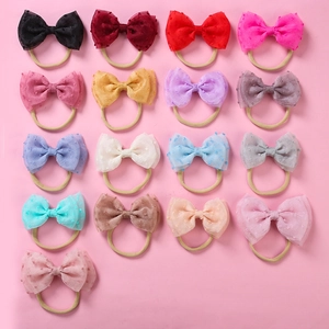 Détail de dix-sept bandeaux bébé en nylon souple avec des nœuds en maille colorée