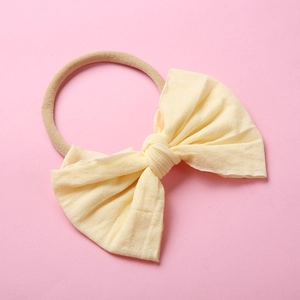 Détail d'un bandeau nœud bébé jaune pâle doux avec une bande en nylon extensible