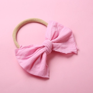 Gros plan détaillé d'un bandeau pour bébé en nylon souple avec un nœud en coton rose