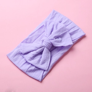 Close-up of soft lavender nylon headband with a large double-layered bow for babies