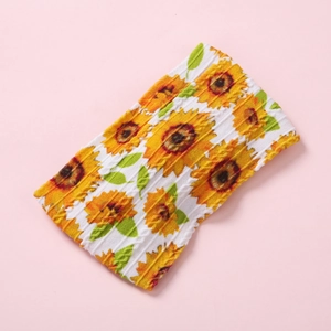 Détail de l'imprimé tournesol sur la texture côtelée blanche du bandeau pour bébé