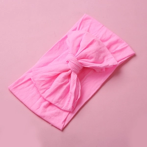 Close-up of pink soft nylon baby headband with a large decorative double-layered bow