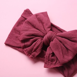 Detailed macro view of soft burgundy nylon headband with large double-layered bow
