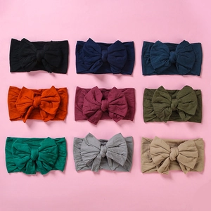 Set of nine soft nylon elastic baby headbands with double-layered bows in assorted colors