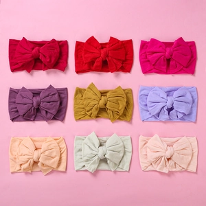 Detail showing 9 colors of soft ribbed nylon baby headbands with large bow knots