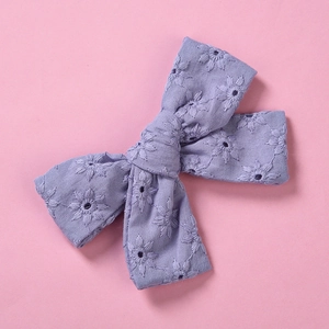 Détails de broderie de marguerites sur une pince à cheveux nœud en coton lavande