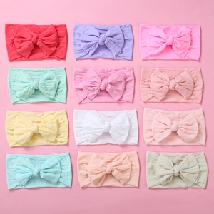Flat lay of 12 colorful soft nylon bow headbands for infant baby girls hair accessories