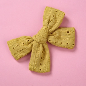 Détail d'une pince à cheveux jaune en dentelle avec broderie florale délicate