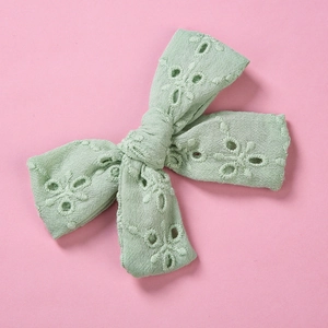 Gros plan détaillé d'une barrette à cheveux en dentelle brodée vert menthe pour fille