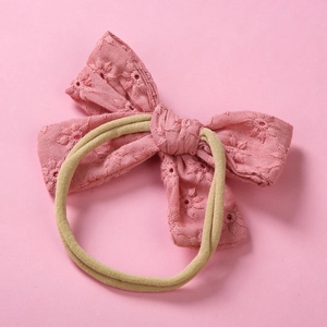 Close-up of pink cotton bow headband with floral embroidery and soft nylon elastic band