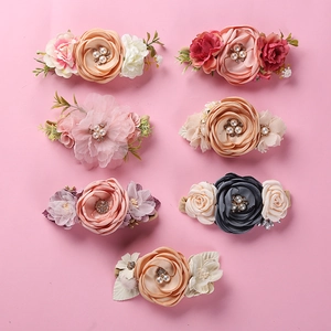 Detailed close-up of handmade 3D fabric flower hair clips with pearls and rhinestones