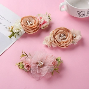 Detail of floral hair clips with pearls and rhinestones for girls on pink background