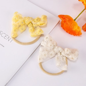 Bandeau en nylon avec nœud en dentelle et broderie de marguerites en jaune et blanc