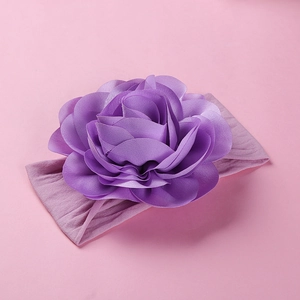Close-up of a large purple fabric flower on a soft elastic nylon headband for infants