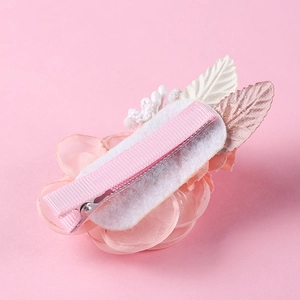 Detailed back view of a pink fabric flower hair clip showing the metal duckbill clamp mechanism