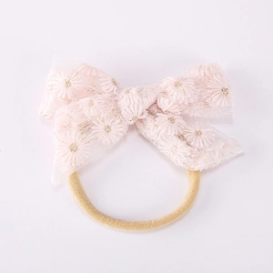 Détail du nœud en dentelle rose avec broderie marguerite et bandeau en nylon élastique