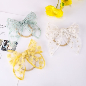 Détail de trois bandeaux en dentelle avec broderie marguerite en bleu, blanc et jaune