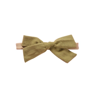 Detailed view of handmade olive green textured cotton bow with stretchy nylon baby headband
