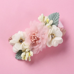 Detail of fabric flower hair clip with pearls and rhinestones on pink background
