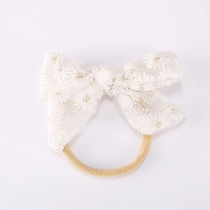 Détail du nœud en dentelle blanche avec broderies marguerites et bandeau en nylon