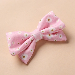 Vue détaillée d'une barrette à fleurs roses avec motifs de marguerites sur fond beige uni