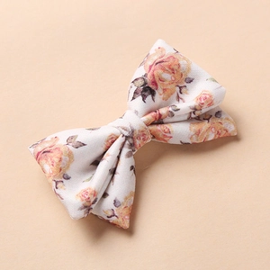 Gros plan d'une pince à cheveux pour bébé à motif floral jaune et rose vintage