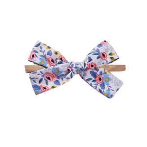 Detailed macro view of soft floral bow nylon headband for baby with rose print