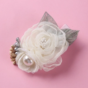 Detailed view of handmade chiffon flower hair clip with pearl center and wrapped metal base