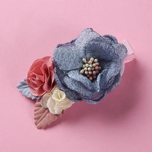 Detailed view of handmade blue mesh flower and ribbon rose on pink fabric covered hair clip