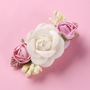 Detail of floral hair clip featuring realistic white and pink roses with soft fabric texture