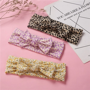 Bandeaux bébé avec nœuds, motifs floraux et léopard, présentés sur un fond rose