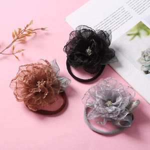 Détails de trois bandeaux bébé avec fleurs en maille 3D noir, marron et gris argenté