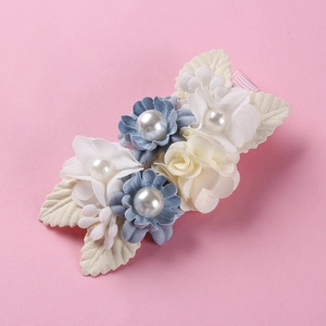 Detail of fabric flower hair clip with pearls on a textured pink ribbon base