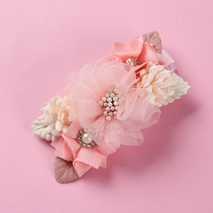 Detail of pink 3D gauze flower hair clip with pearl center and satin petals