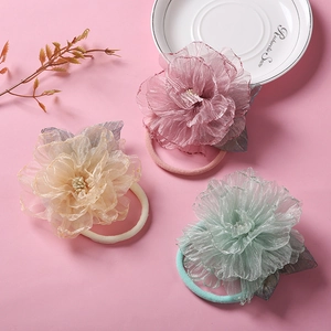 Détail de trois bandeaux bébé avec fleurs en maille rose beige et vert menthe