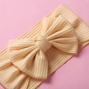 Dettaglio della fascia per neonati in maglia a coste gialla con fiocco elastico