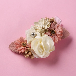 Detail of handmade 3D silk flowers hair clip with pearls and rhinestones on pink ribbon
