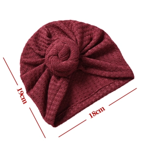 Flach liegende weinrote Waffelstrick-Babymütze mit Maßen von 19 cm x 18 cm gezeigt