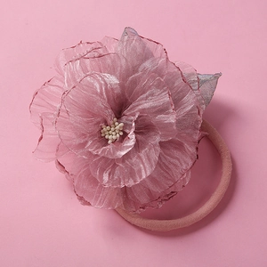 Détail du bandeau fleur en maille rose avec pétales doux et feuille argentée brillante