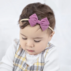 Detail of purple cotton linen bow headband on baby girl with soft nylon band