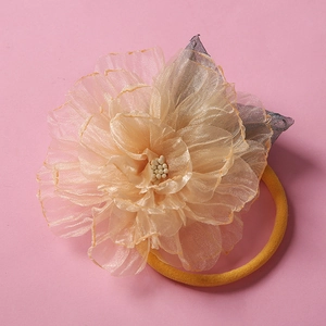 Détail de la fleur en organza beige avec bandeau élastique jaune doux pour bébé