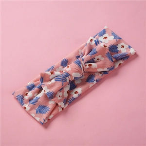 Détail du bandeau fleuri pour bébé montrant le tissu en maille élastique et le nœud