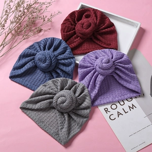 Detail der Waffelstrick-Struktur bei Baby-Turban-Mützen mit Donut-Knoten in vier Farben