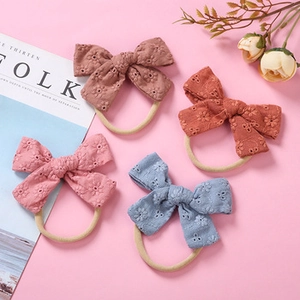 Close-up of four floral embroidered cotton baby headbands in vintage candy colors