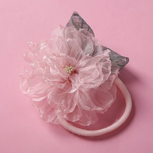 Détail d'un bandeau fleur en maille rose pour bébé avec bande nylon douce et pétales 3D