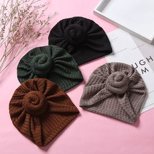 Detail von vier Waffelstrick-Babyturbanen mit Donut-Knoten-Design aus weichem Stoff