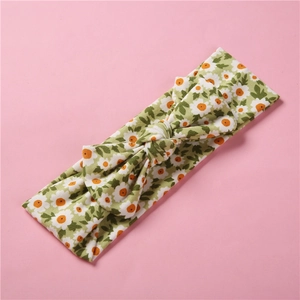 Détail du bandeau bébé en coton à fleurs avec imprimé marguerites et design noué